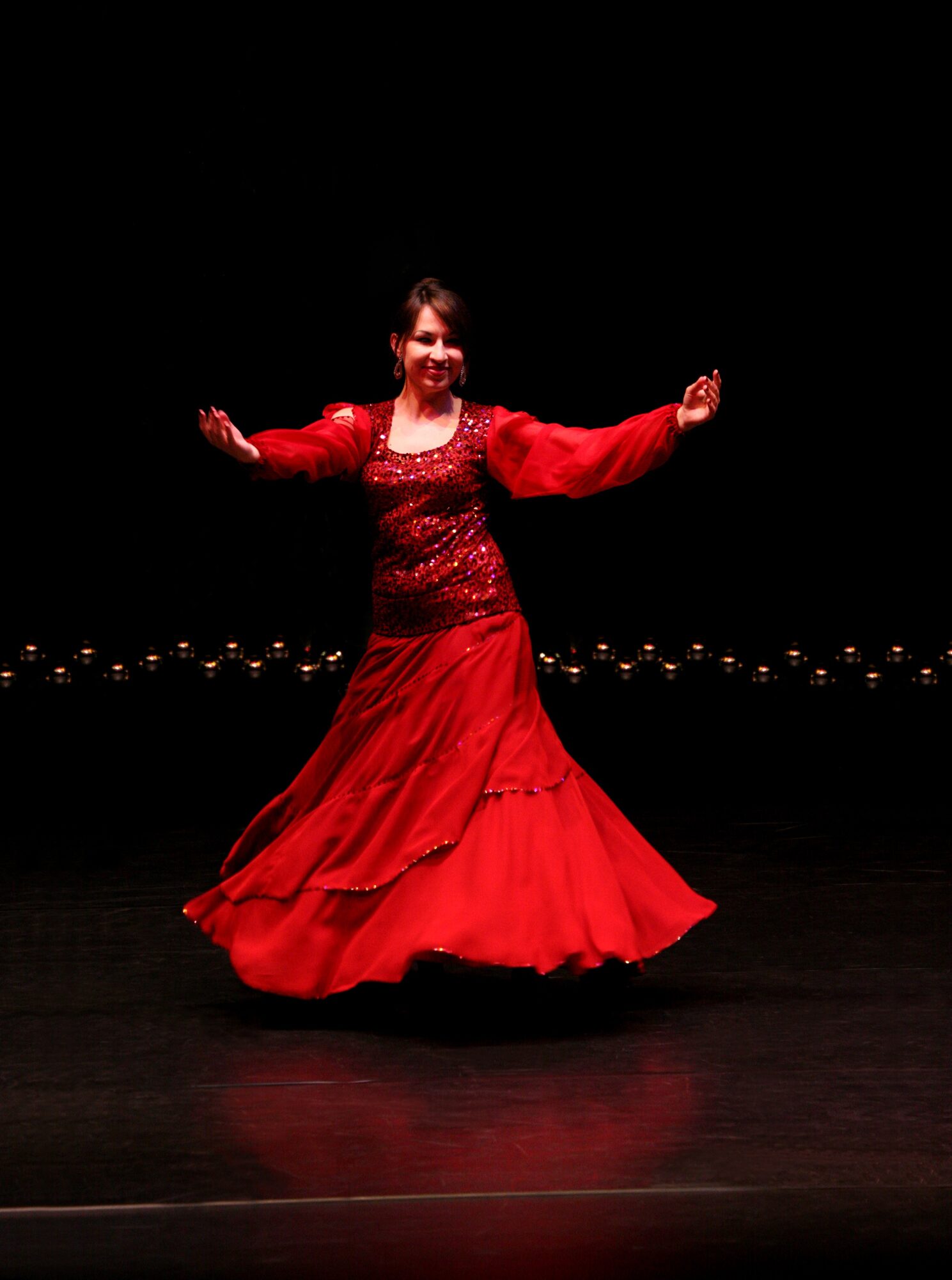 Beatrice Metzler in rotem Kleid, lächelnd auf der Bühne