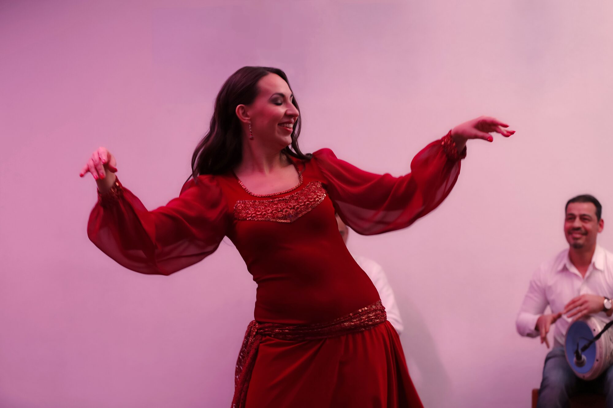 Beatrice Metzler im roten Kleid mit Trommler im Hintergrund
